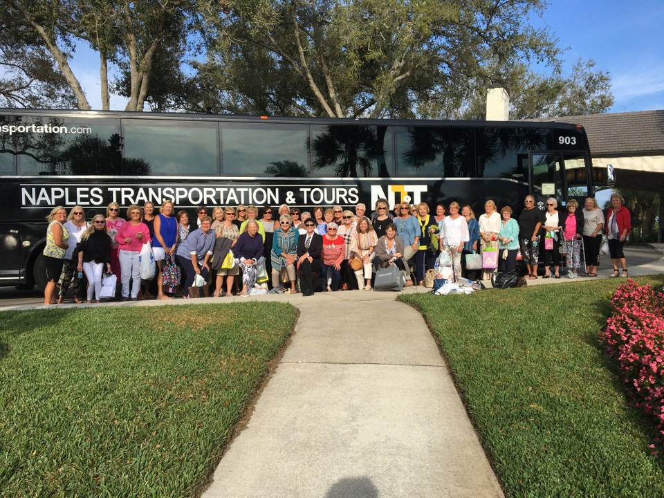 A group of people outside of the charter bus