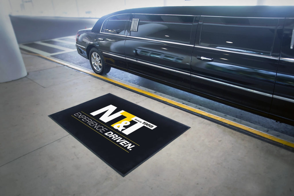 A limo at the airport with the NT & T logoed rug on the ground