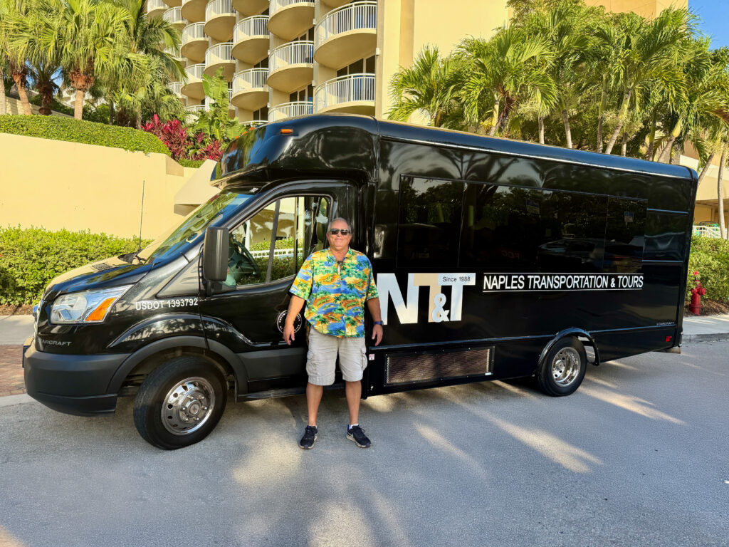 Tour guide Kenny Hill standing in front of the tour bus.