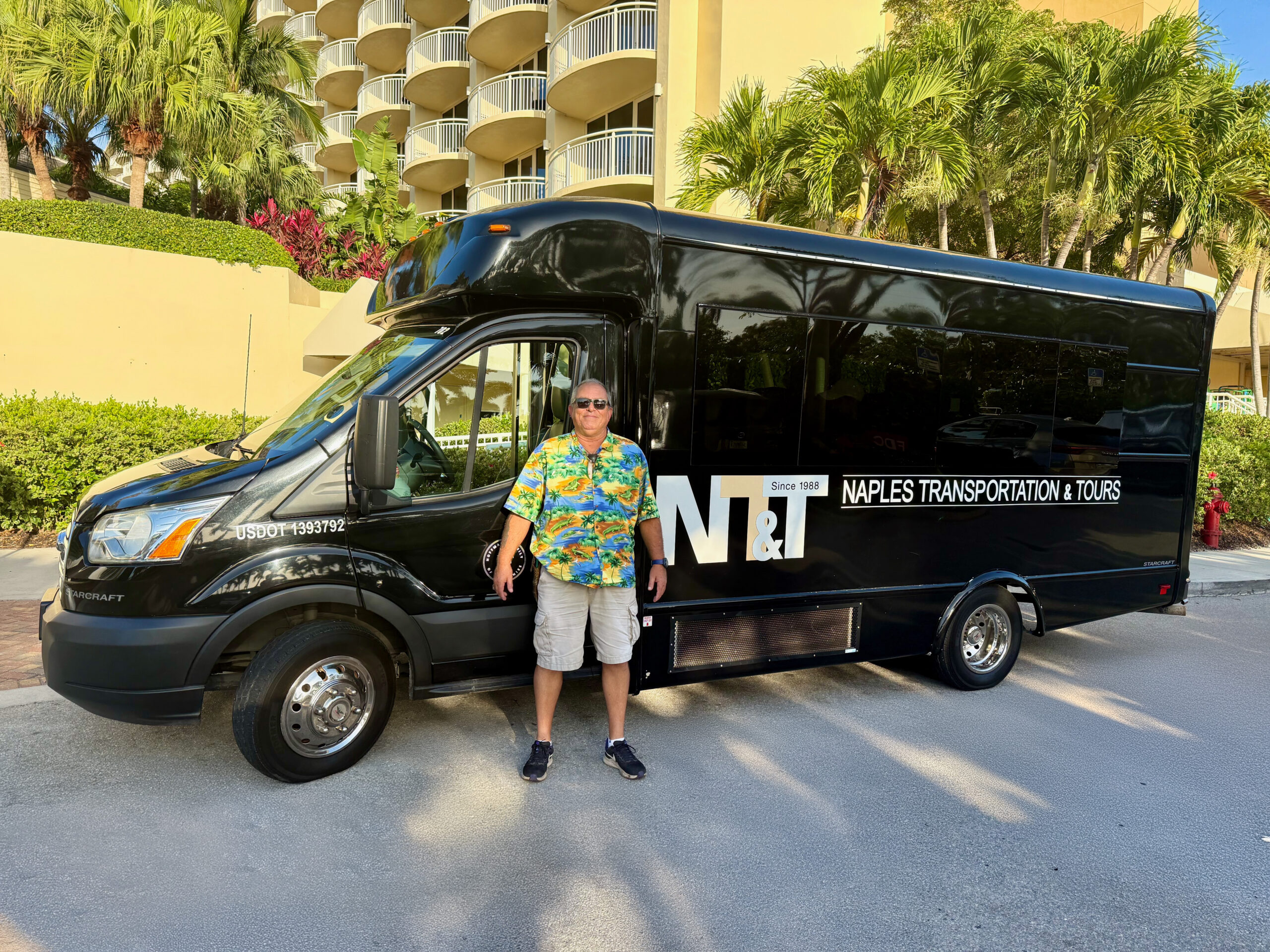 Tour guide Kenny Hill standing in front of the tour bus.