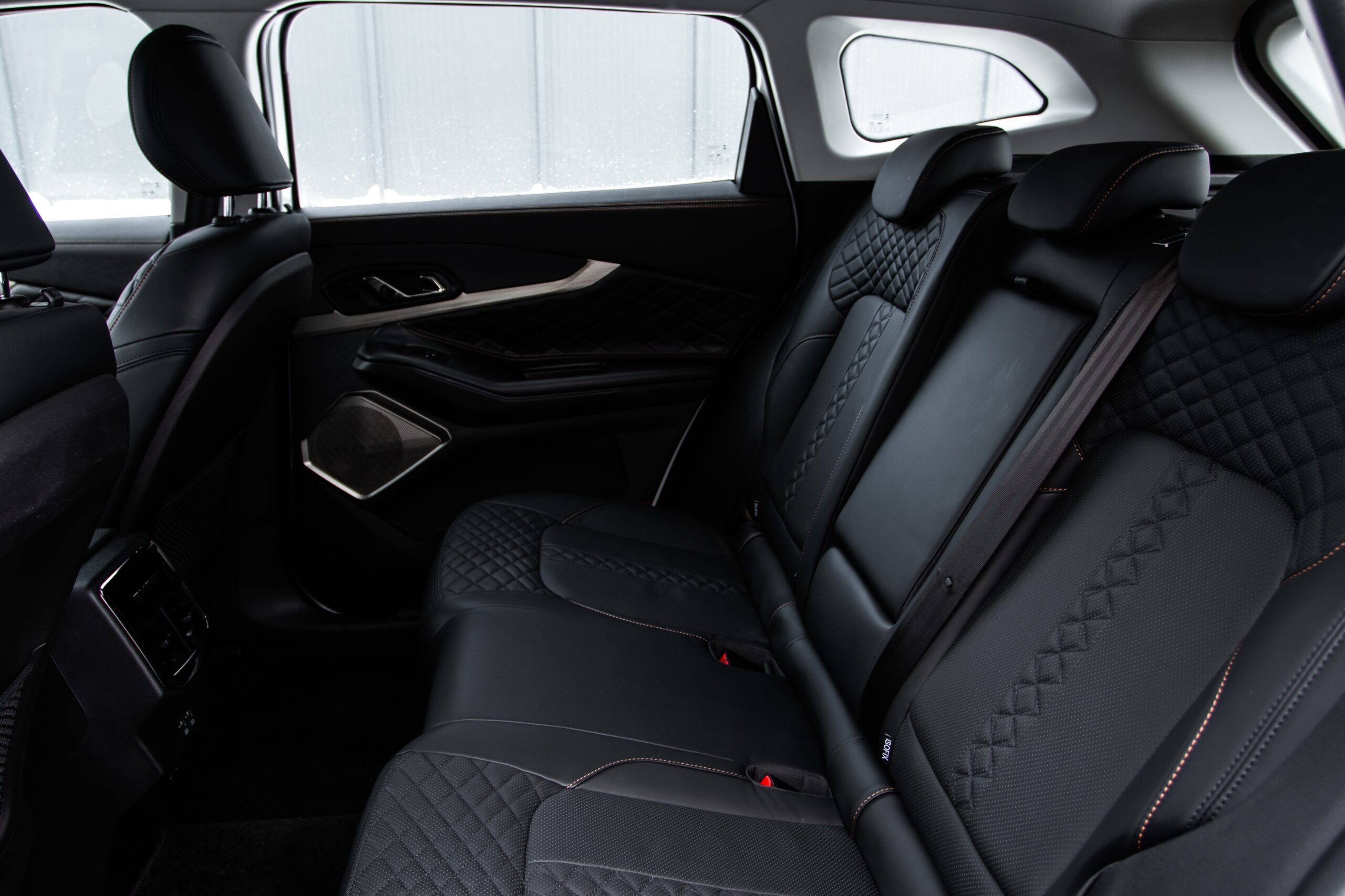 the back seats of a modern SUV with black leather seats