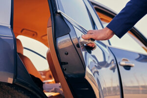 Chauffeur opening the door of a luxury private car service vehicle.